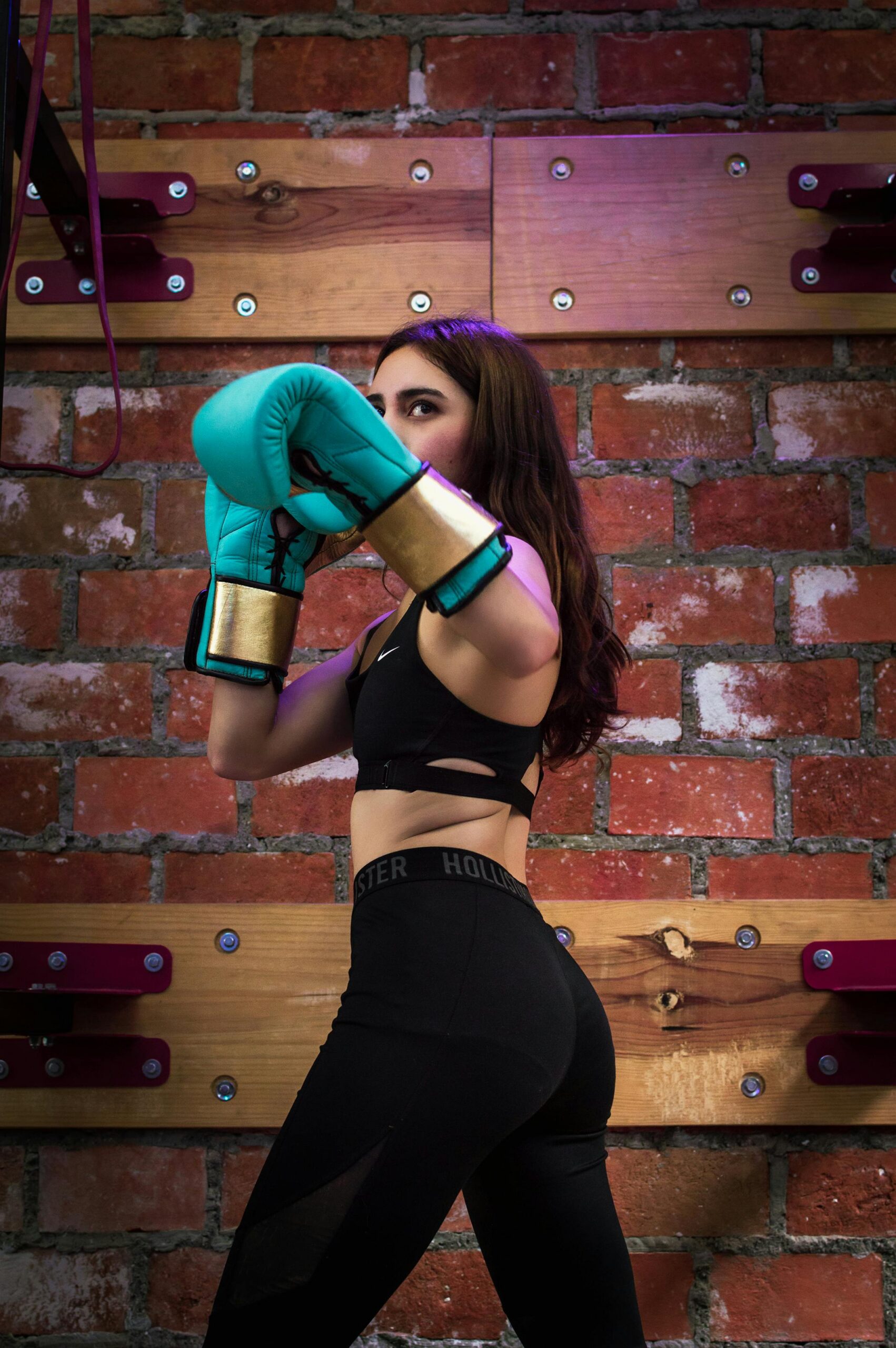A woman in active wear boxing indoors, showcasing strength and focus.